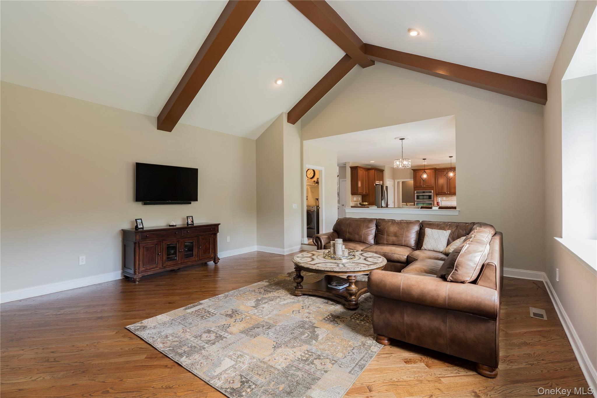 78 Moore Road Hopewell Junction, NY 12533 - Photo 19 of 38 Living room with beamed ceiling, light wood-style floors, a chandelier, high vaulted ceiling, and recessed lighting