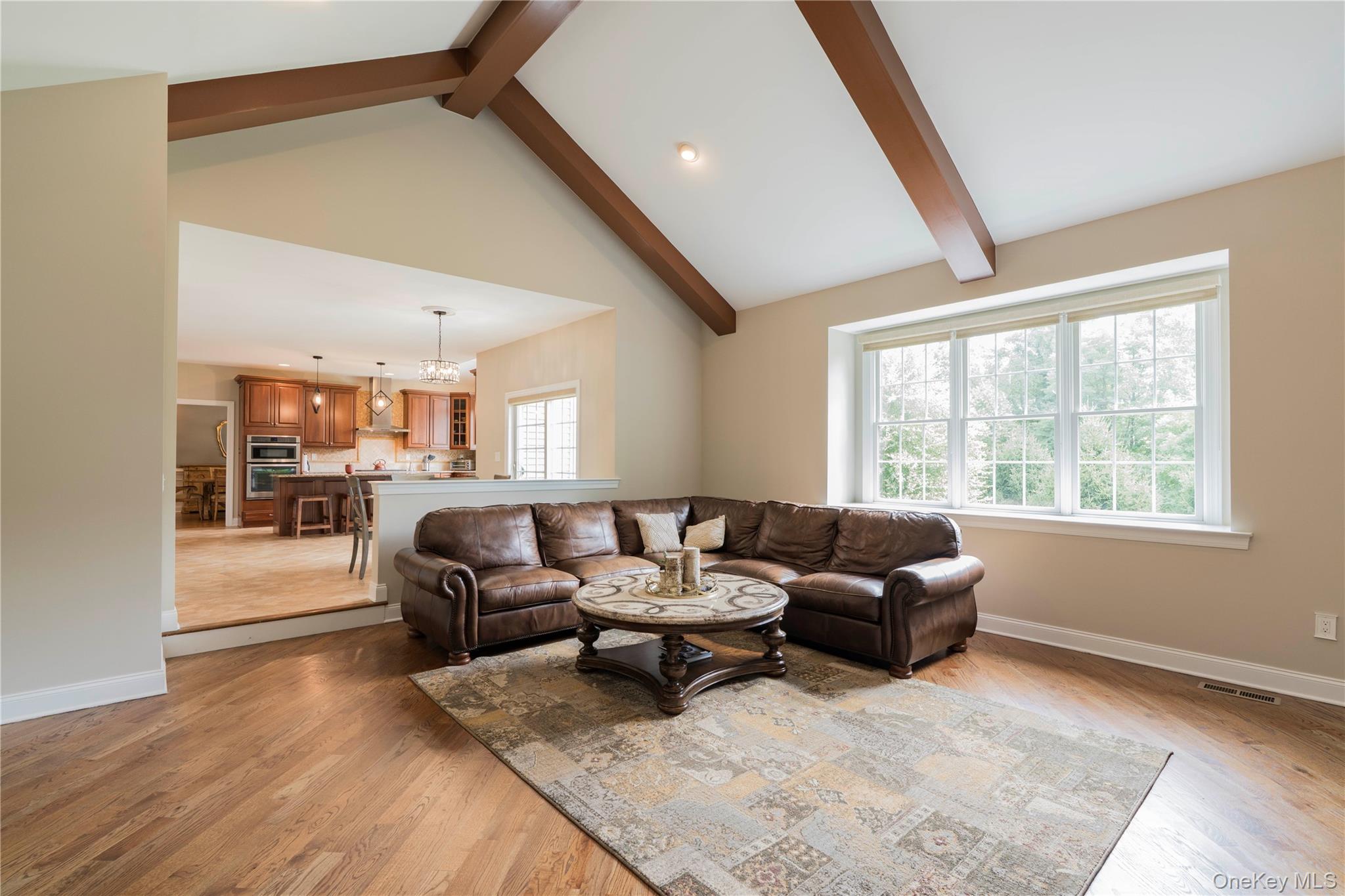 78 Moore Road Hopewell Junction, NY 12533 - Photo 20 of 38 Living area featuring beam ceiling, light wood-style flooring, high vaulted ceiling, and a chandelier