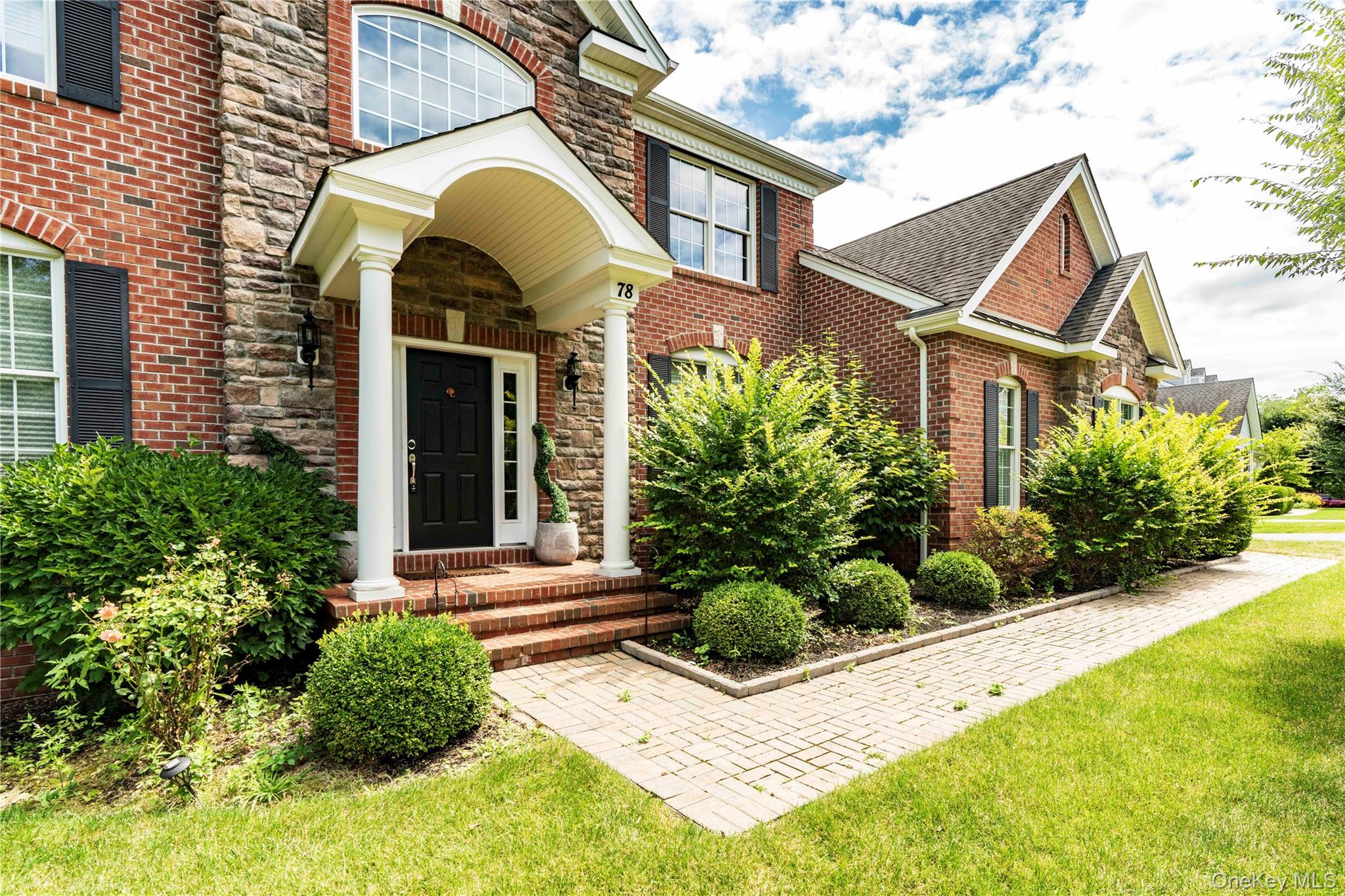 78 Moore Road Hopewell Junction, NY 12533 - Photo 2 of 38 Doorway to property featuring brick siding, stone siding, a lawn, and roof with shingles