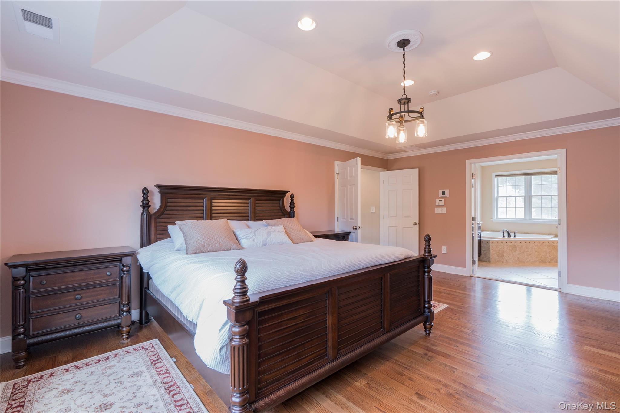 78 Moore Road Hopewell Junction, NY 12533 - Photo 22 of 38 Bedroom with a raised ceiling, wood finished floors, ornamental molding, ensuite bath, and recessed lighting