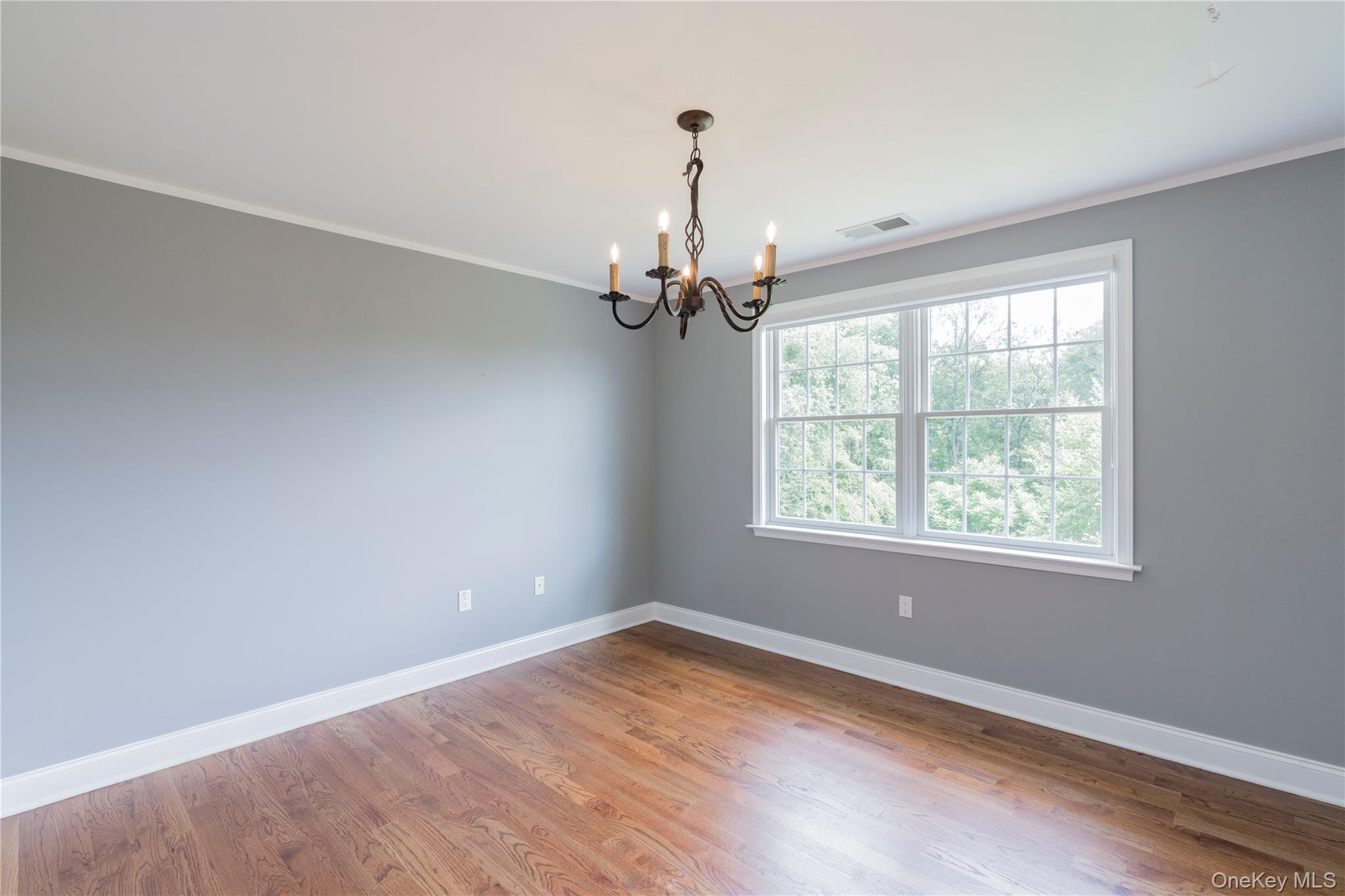 78 Moore Road Hopewell Junction, NY 12533 - Photo 30 of 38 Empty room featuring crown molding, wood finished floors, and a chandelier