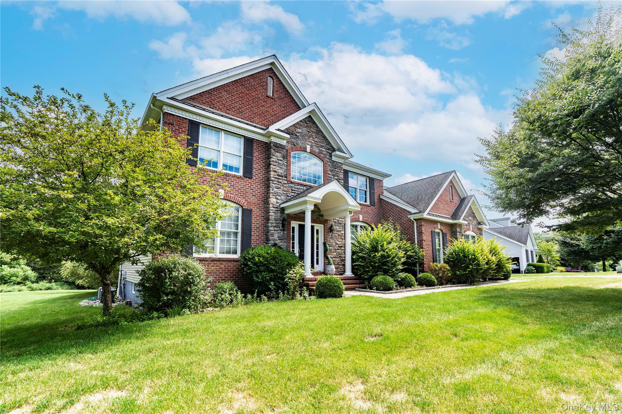 78 Moore Road Hopewell Junction, NY 12533 - Photo 32 of 38 View of front facade featuring stone siding, brick siding, and a front lawn