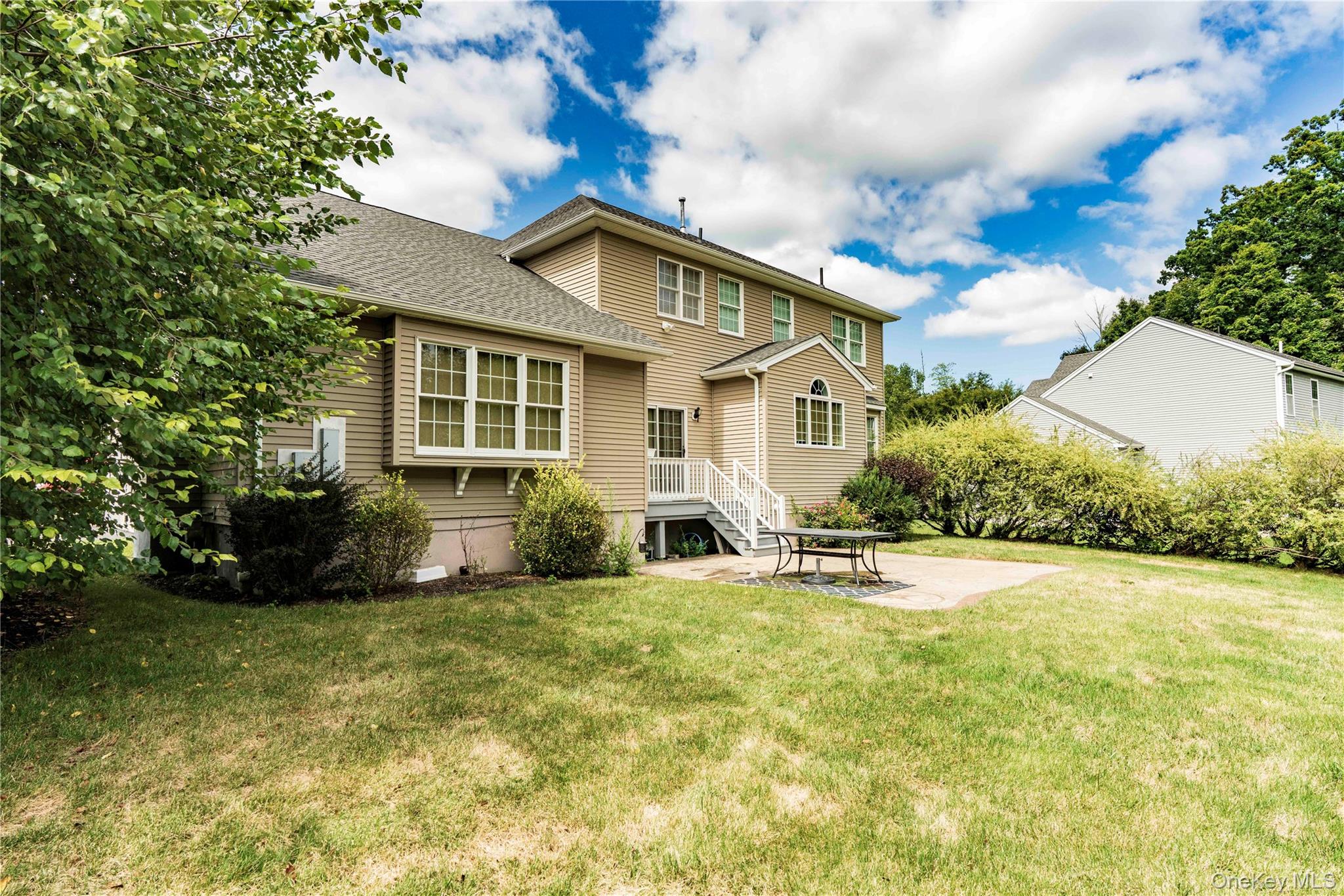 78 Moore Road Hopewell Junction, NY 12533 - Photo 34 of 38 Rear view of property with a patio area, a shingled roof, and a lawn