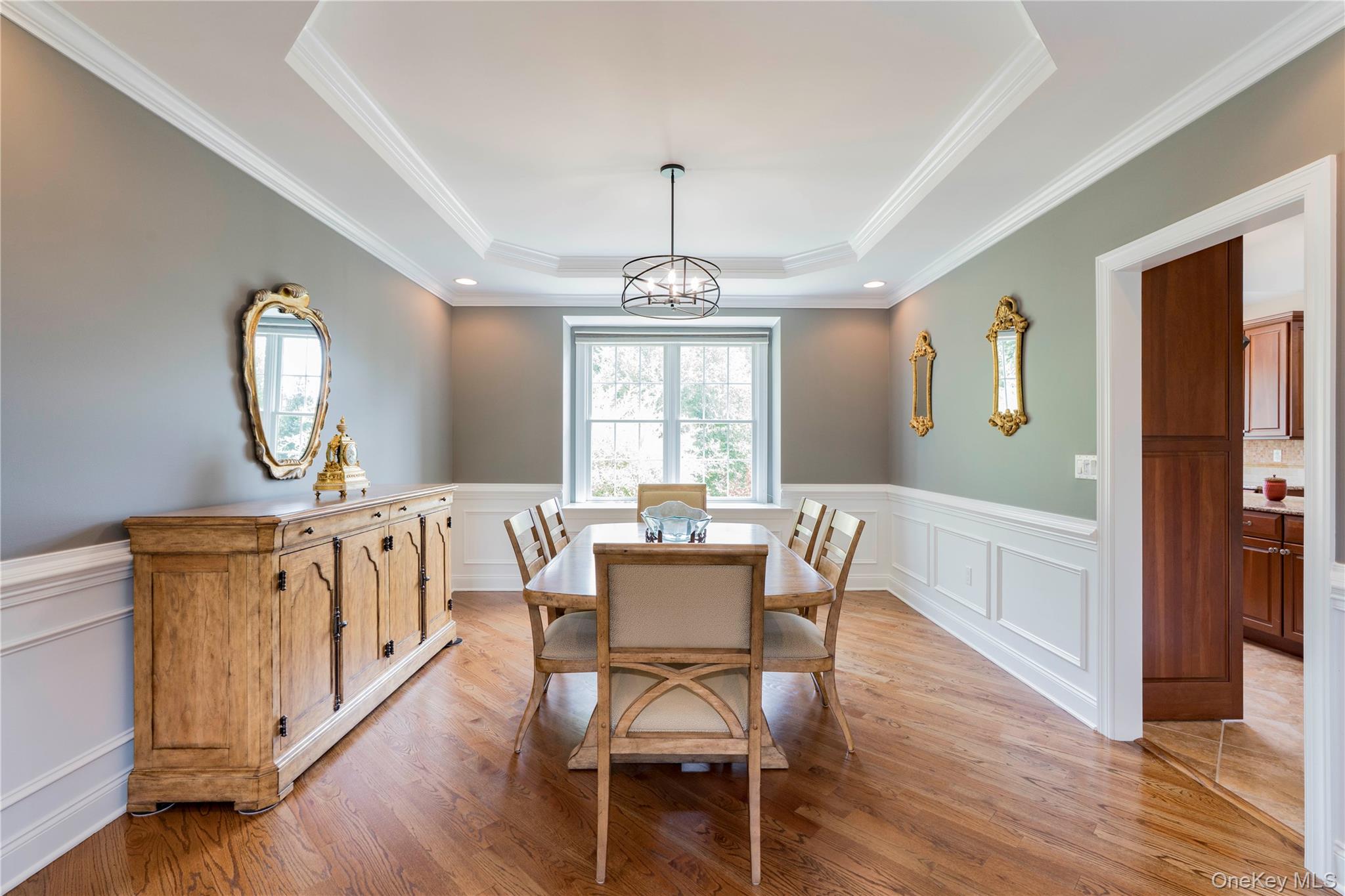78 Moore Road Hopewell Junction, NY 12533 - Photo 9 of 38 Dining area featuring a raised ceiling, crown molding, light wood finished floors, a decorative wall, and a wainscoted wall