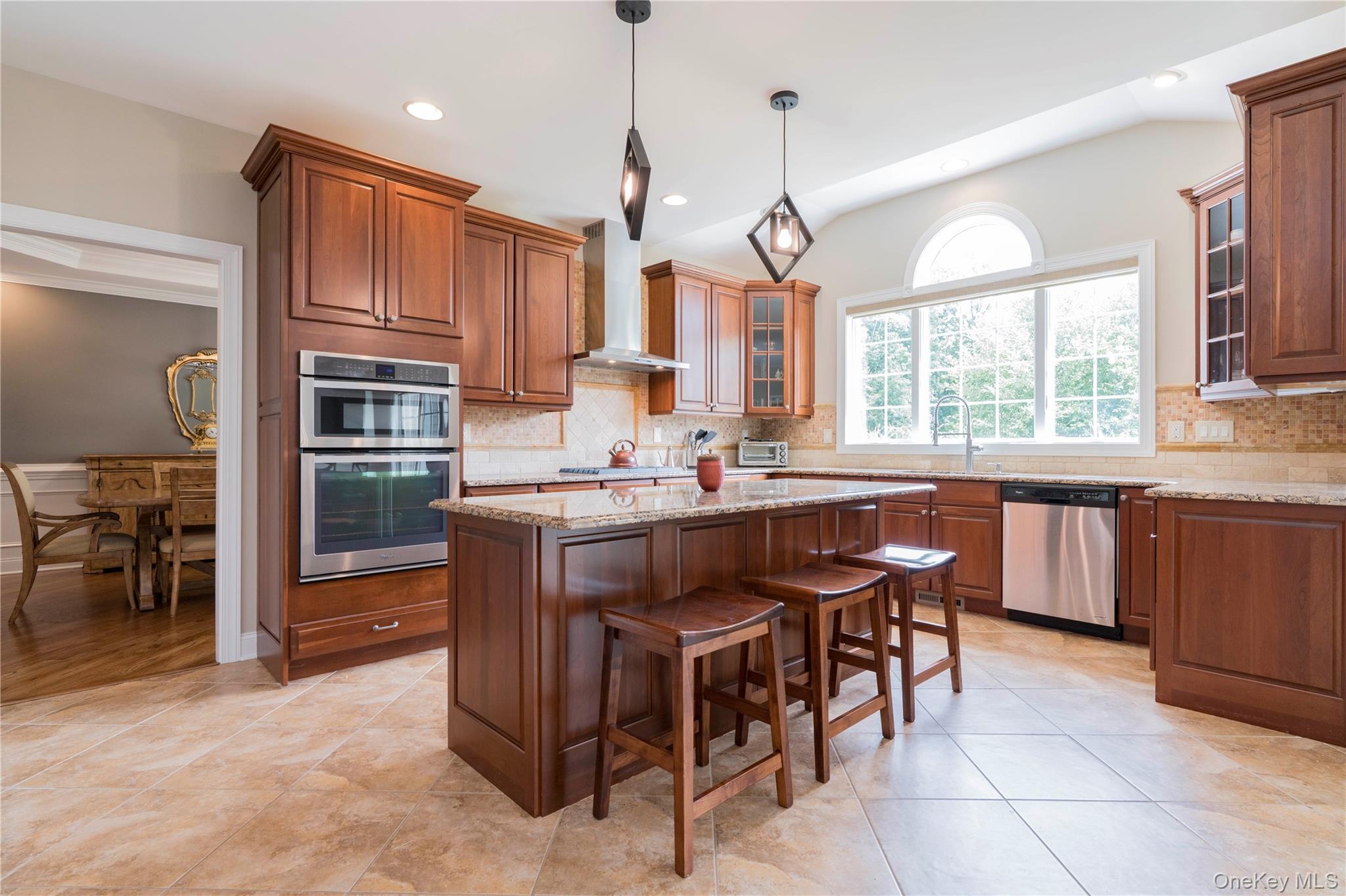 78 Moore Road Hopewell Junction, NY 12533 - Photo 10 of 38 Kitchen with glass insert cabinets, pendant lighting, a center island, light stone counters, and a kitchen breakfast bar