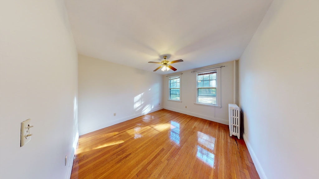 32 Sidlaw Road, Unit 7 Boston, MA 02135 - Photo 5 of 10 a view of an empty room with window and wooden floor