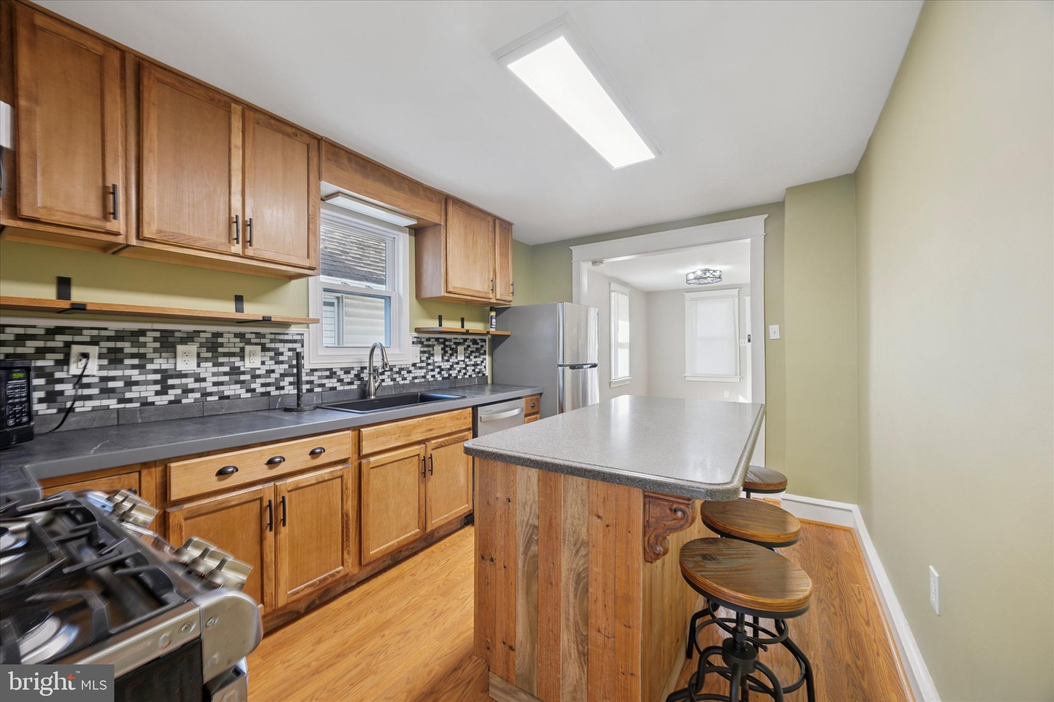 1035 Langley Street Trainer, PA 19061 - Photo 3 of 16 a kitchen with stainless steel appliances granite countertop a sink stove and cabinets