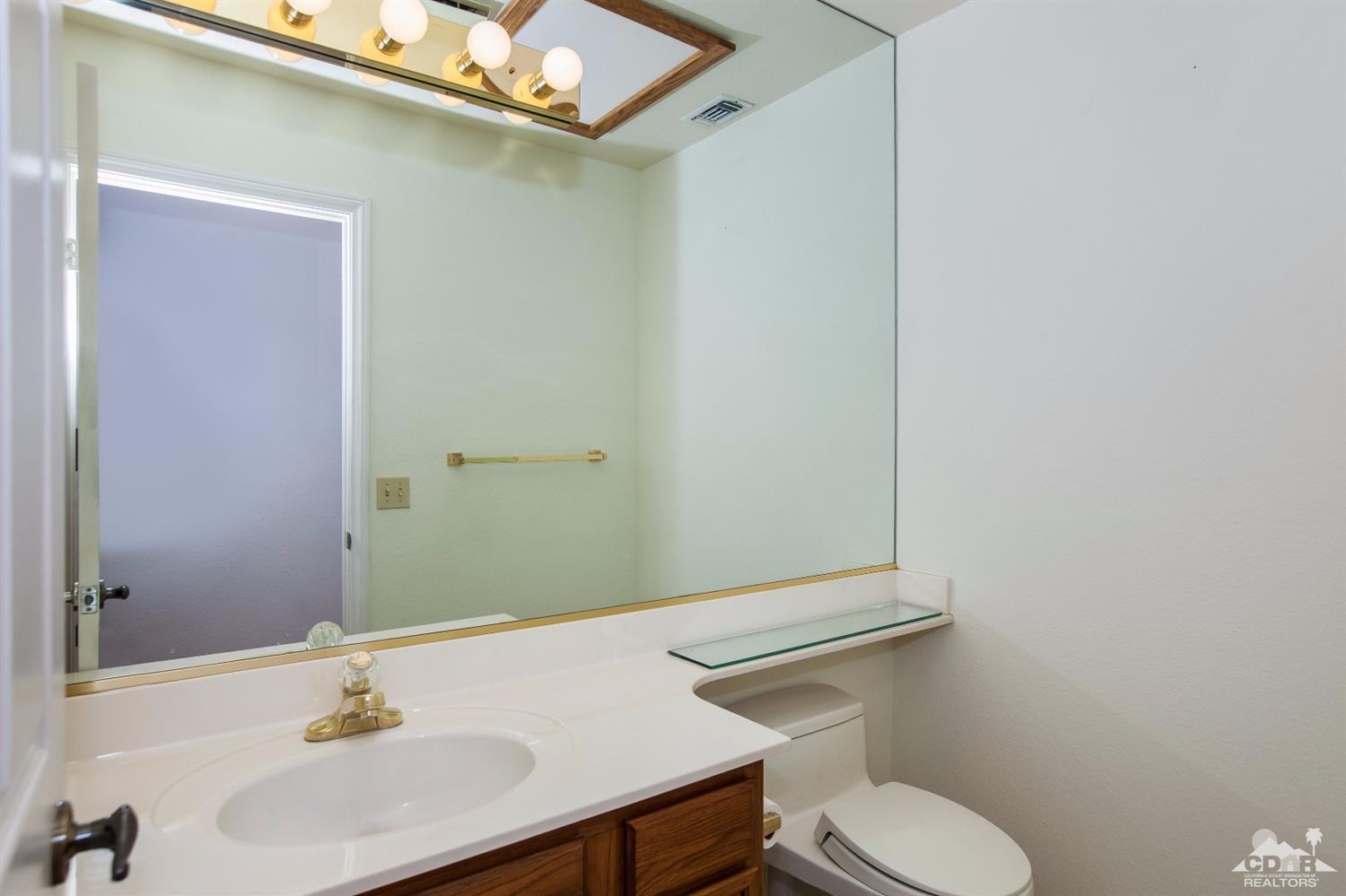 68640 Los Gatos Road Cathedral City, CA 92234 - Photo 15 of 33 a bathroom with a sink a toilet and mirror