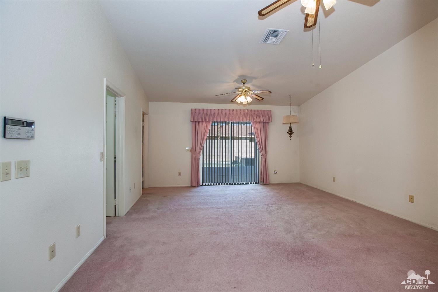 68640 Los Gatos Road Cathedral City, CA 92234 - Photo 19 of 33 an empty room with chandelier fan and windows