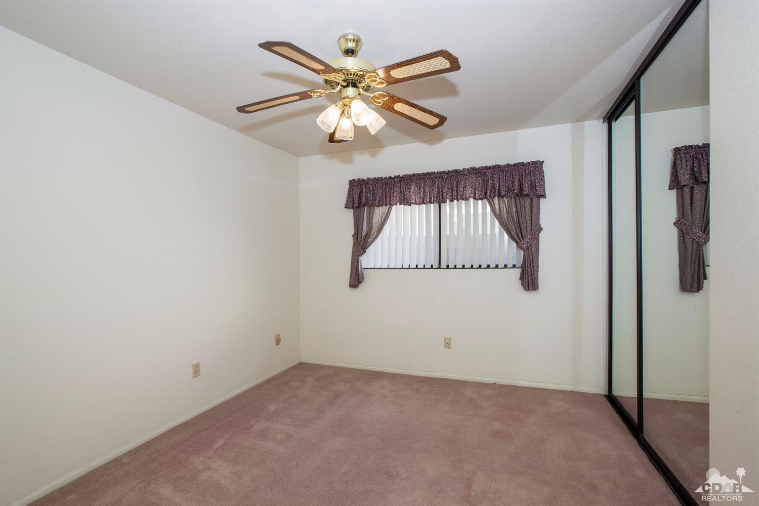 68640 Los Gatos Road Cathedral City, CA 92234 - Photo 26 of 33 an empty room with windows and fan