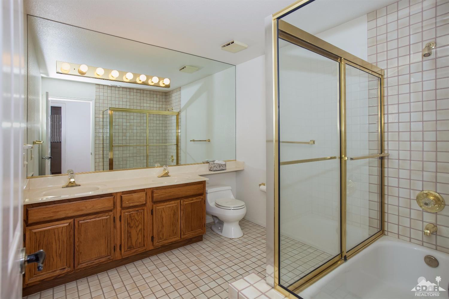 68640 Los Gatos Road Cathedral City, CA 92234 - Photo 28 of 33 a spacious bathroom with a double vanity sink toilet and shower