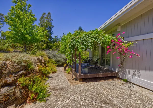 a view of a house with backyard sitting area and garden