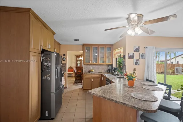 a kitchen with a refrigerator a kitchen island a stove and furniture