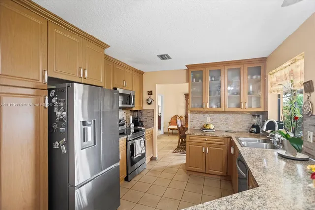 a kitchen with stainless steel appliances granite countertop a refrigerator stove and sink