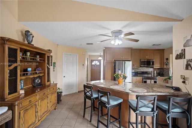 a kitchen with a dining table and chairs with cabinets