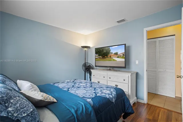 a bedroom with a bed and a flat screen tv