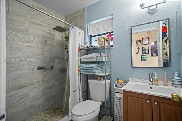 a bathroom with a granite countertop toilet sink and shower