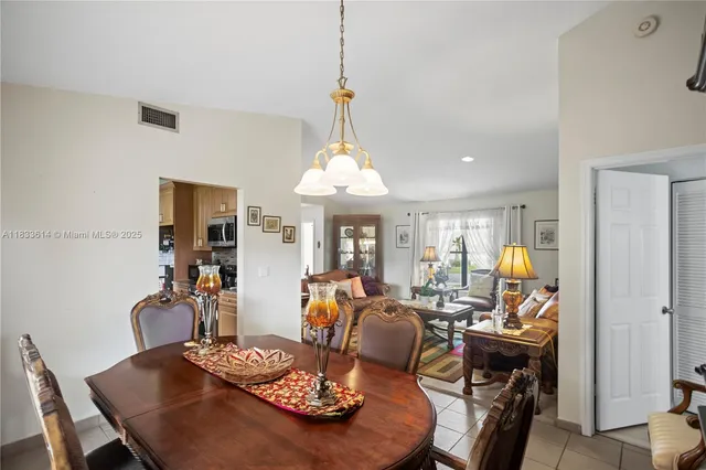 a view of a dining room with furniture a chandelier and wooden floor