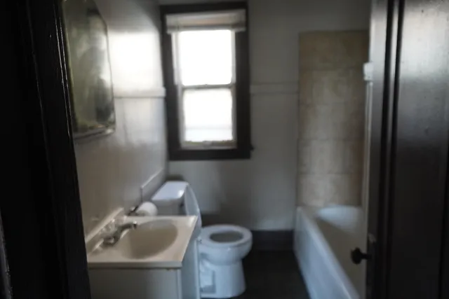 a bathroom with a toilet sink and mirror