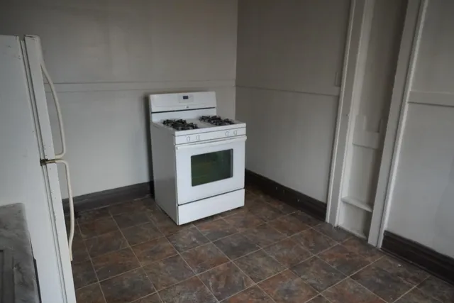 a view of a refrigerator in kitchen and utility room