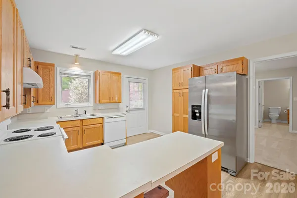 a kitchen with granite countertop a stove cabinets and wooden floor