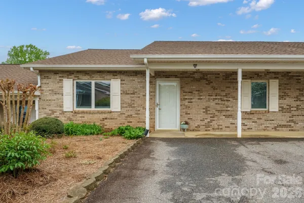 front view of a brick house with a yard