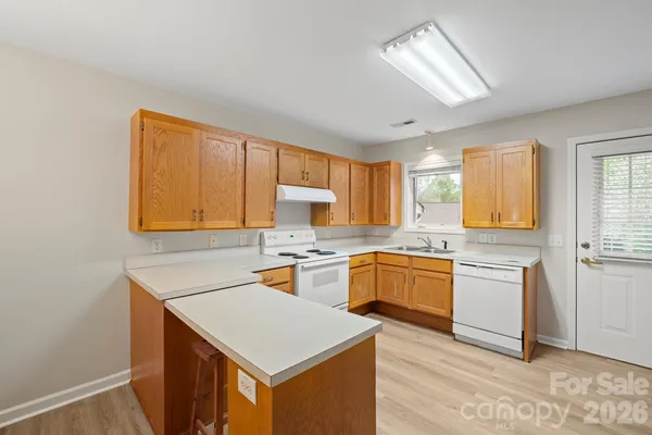 a kitchen with stainless steel appliances granite countertop a refrigerator a stove and a sink with cabinets