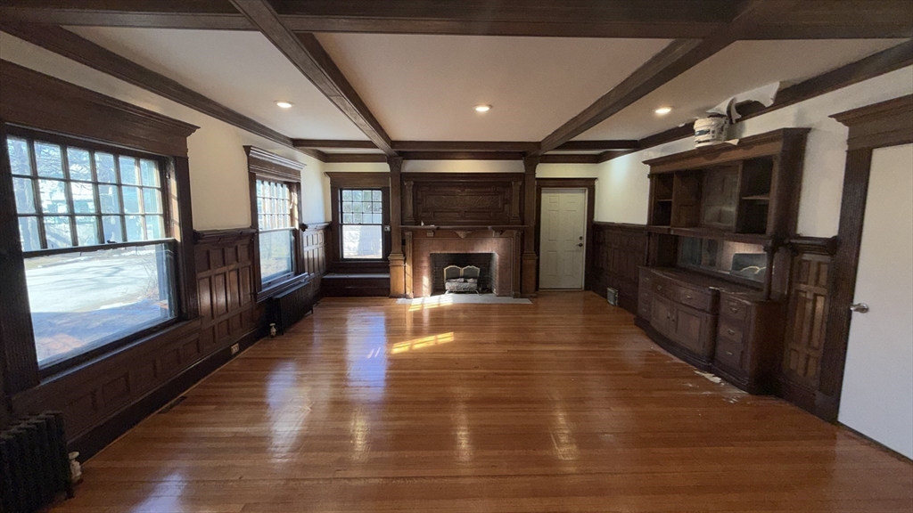 194 Sumner Avenue Springfield, MA 01108 - Photo 16 of 24 a view of an empty room with wooden floor fire place and windows