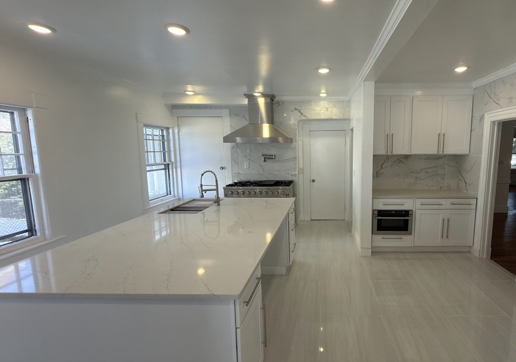 194 Sumner Avenue Springfield, MA 01108 - Photo 2 of 24 a large kitchen with stainless steel appliances a large counter top a stove and a refrigerator