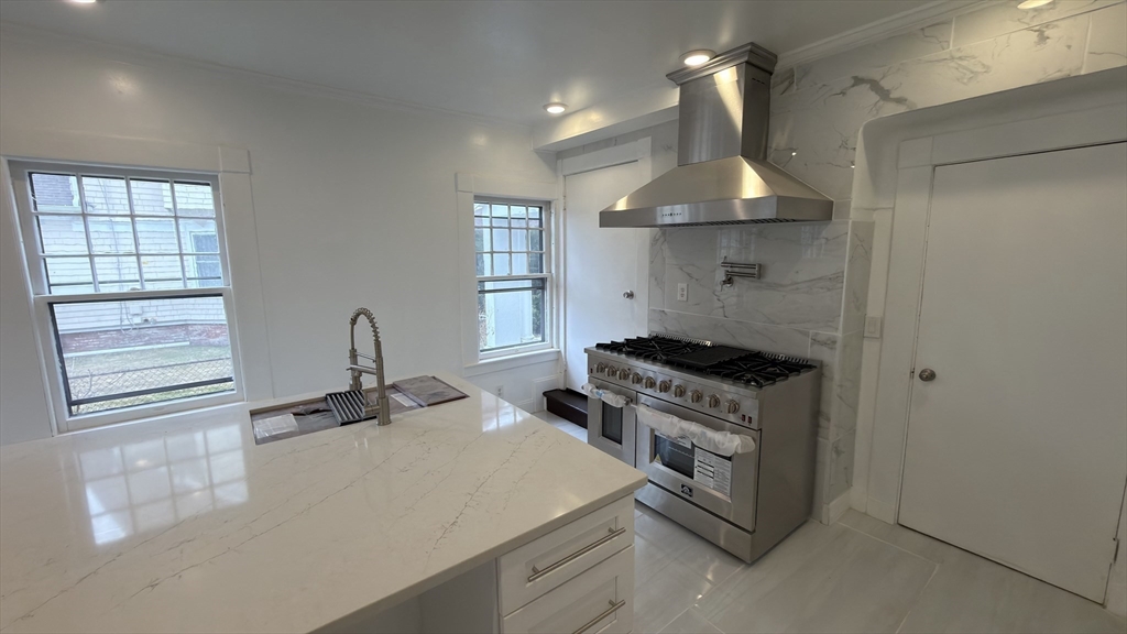 194 Sumner Avenue Springfield, MA 01108 - Photo 5 of 24 a kitchen with a stove a sink and a window