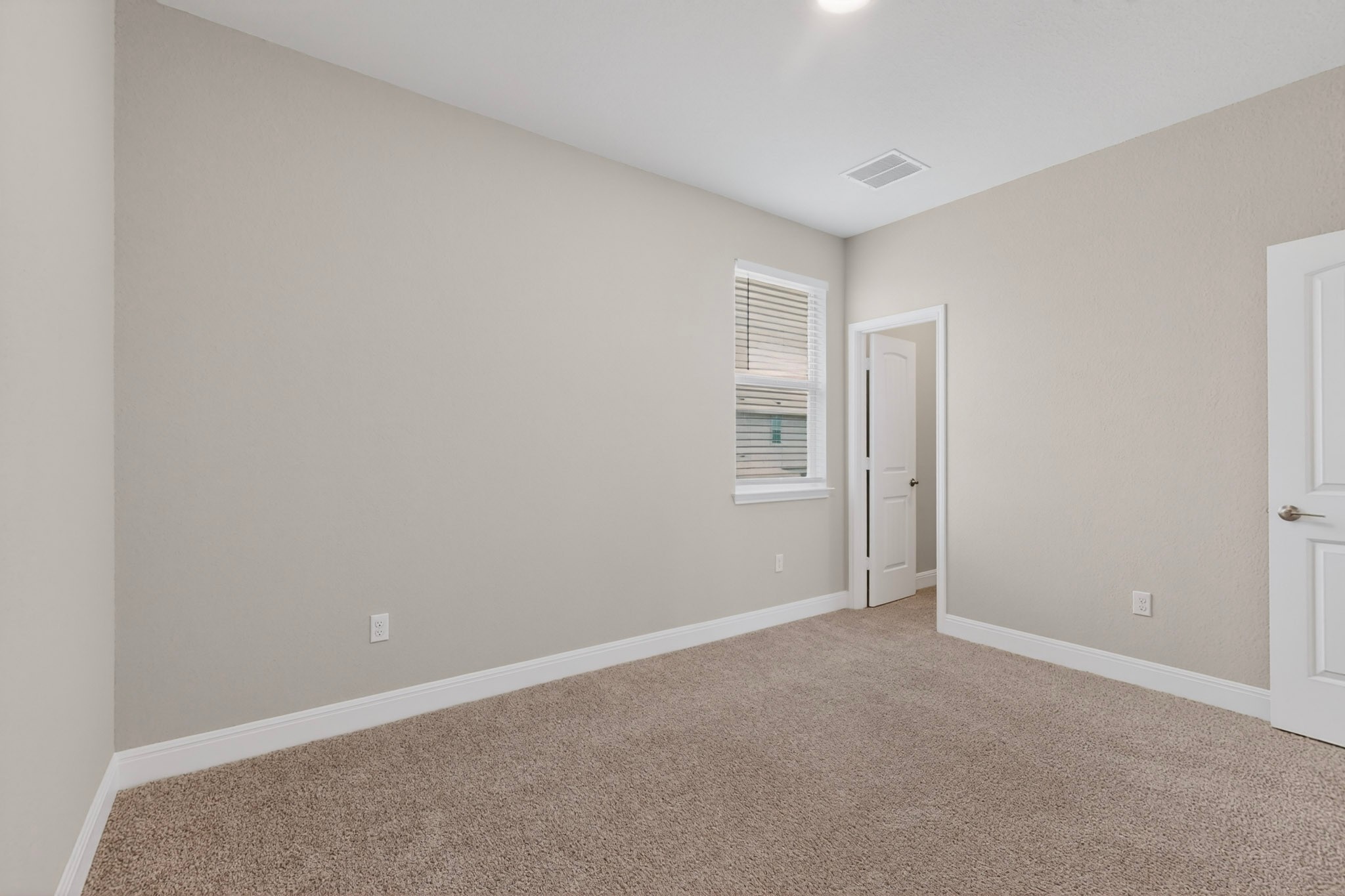 16809 Guido Cove Pflugerville, TX 78660 - Photo 30 of 40 Neutral-toned bedroom featuring plush carpeting, white baseboards, and a single window with horizontal blinds