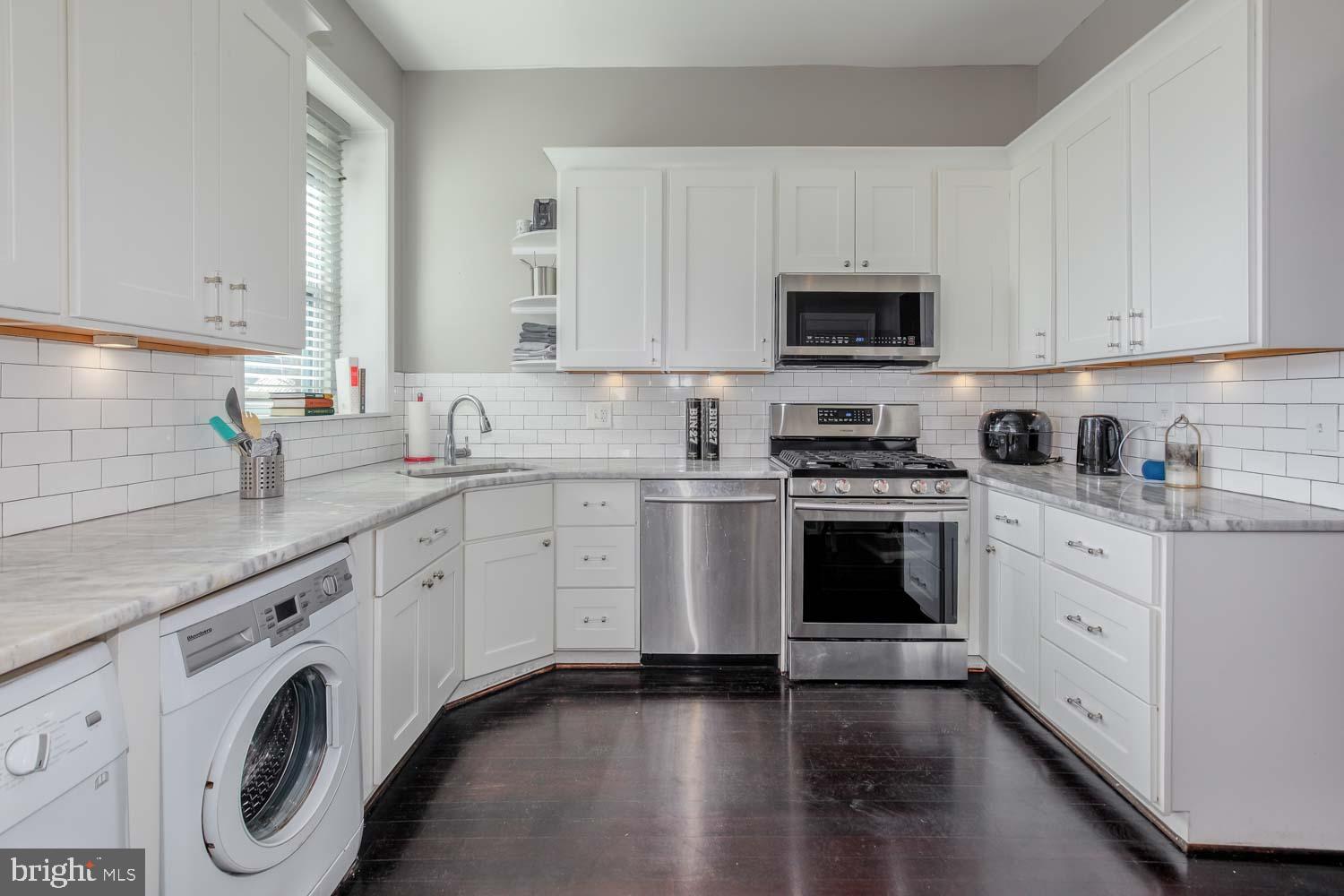 306 M Street Northwest Washington, DC 20001 - Photo 8 of 22 a kitchen with granite countertop white cabinets sink and stainless steel appliances