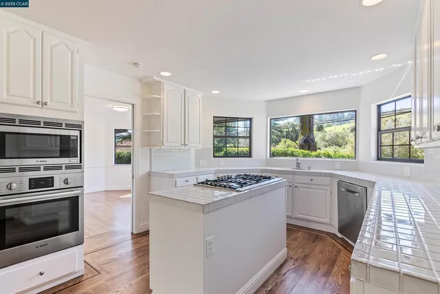 a kitchen with stainless steel appliances kitchen island granite countertop a stove and a refrigerator
