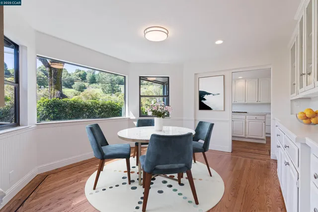 a dining room with furniture a rug and a floor to ceiling window