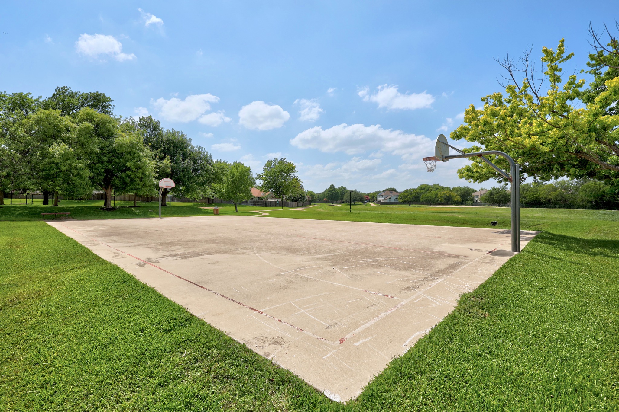 1108 Springbrook Road Pflugerville, TX 78660 - Photo 35 of 37 An outdoor basketball court provides a lively recreation space amidst green surroundings.