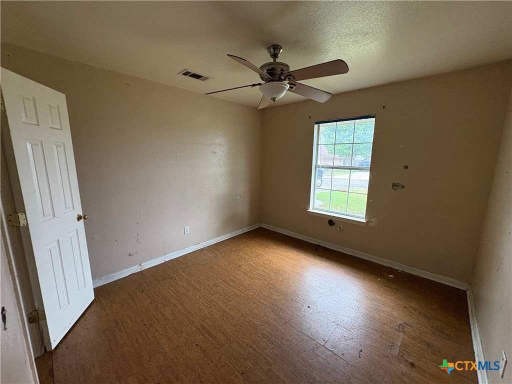 206 Timber Ridge Drive Nolanville, TX 76559 - Photo 16 of 21 an empty room with wooden floor fan and windows