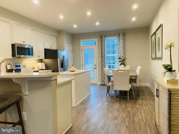 a kitchen with a table chairs appliances and cabinets