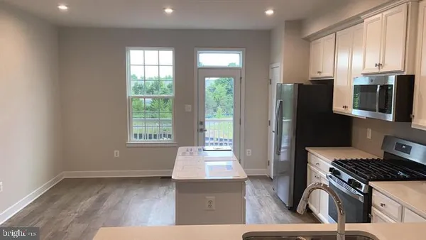 a kitchen with stainless steel appliances granite countertop a stove a refrigerator and a microwave