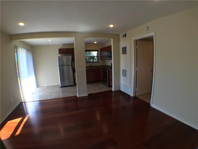 an empty room with wooden floor and entrance