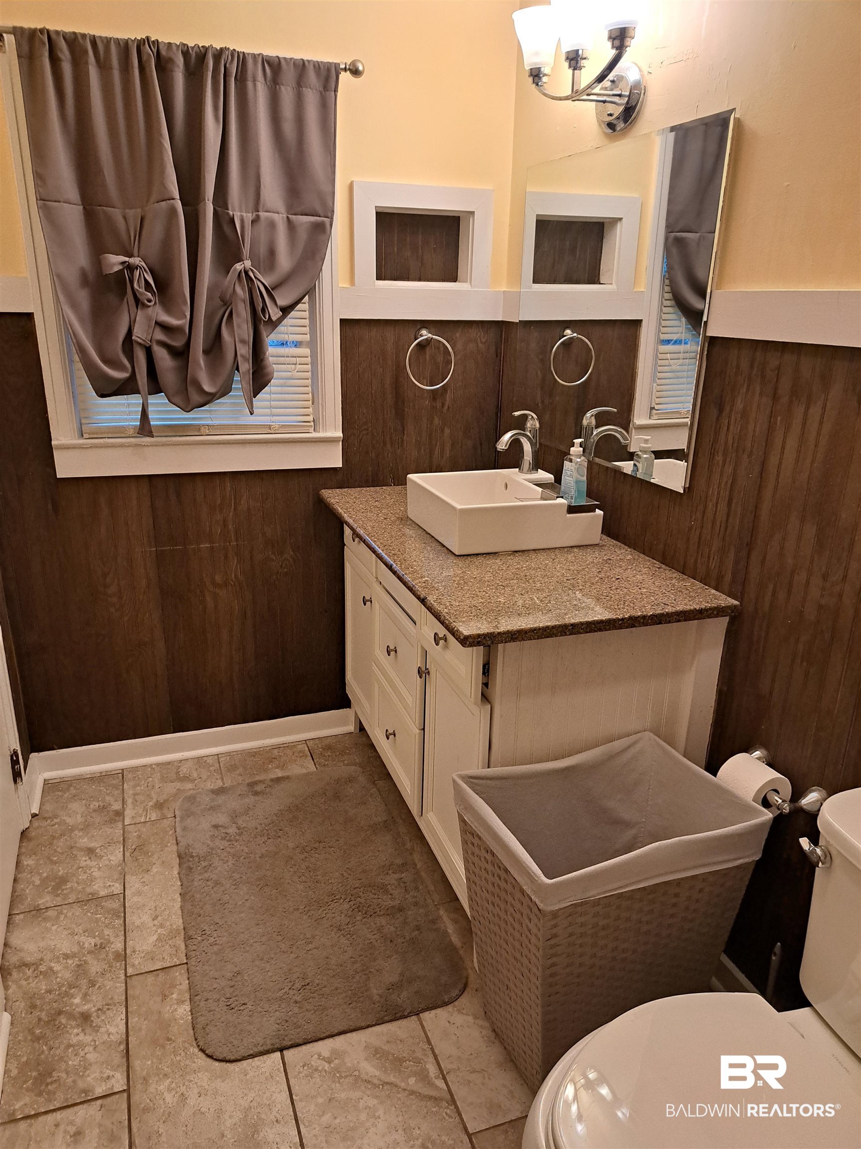 249 Newton Parkway Evergreen, AL 36401 - Photo 15 of 28 Half bathroom featuring vanity and wooden walls