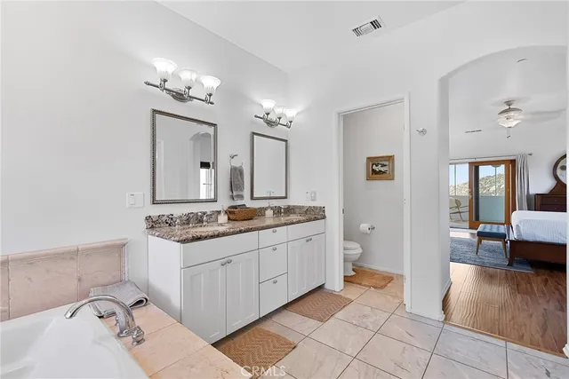 a bathroom with a toilet sink mirror and vanity