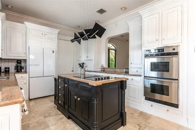 a kitchen with stainless steel appliances granite countertop a stove a sink and a refrigerator