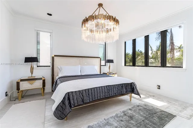 a bedroom with a bed mirror and window