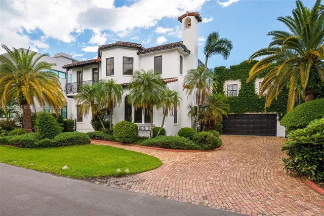 a view of a house with a yard and palm trees