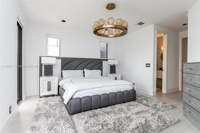 a bedroom with a large bed and a chandelier