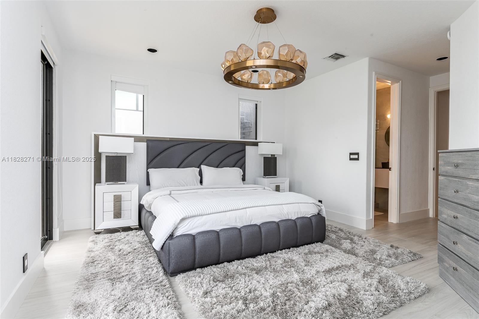 Las Olas Isles Fort Lauderdale, FL 33301 - Photo 22 of 29 a bedroom with a large bed and a chandelier