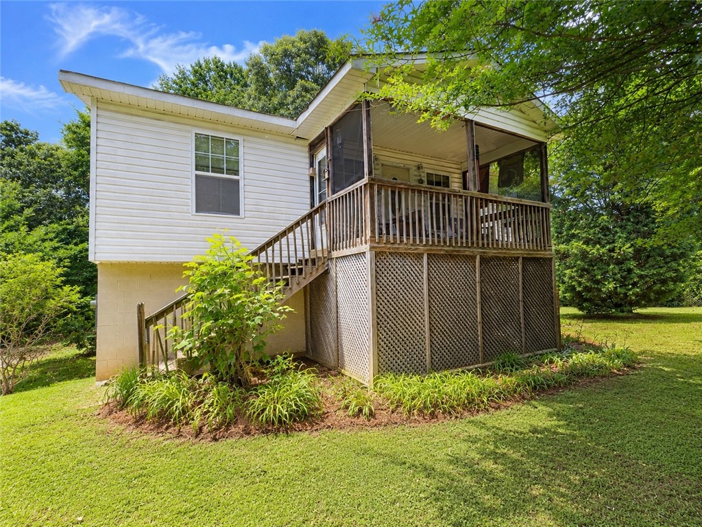 138 Cloverdale Road Seneca, SC 29678 - Photo 1 of 27 A quaint residence featuring a screened porch and accessible stairs amidst a lush, green yard.