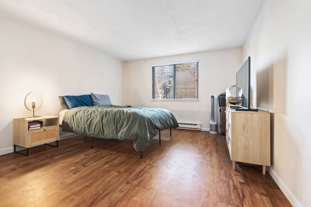 9 Broadway, Unit 210 Saugus, MA 01906 - Photo 13 of 24 a bedroom with furniture and wooden floor