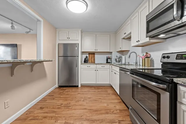 a kitchen with a refrigerator sink and cabinets