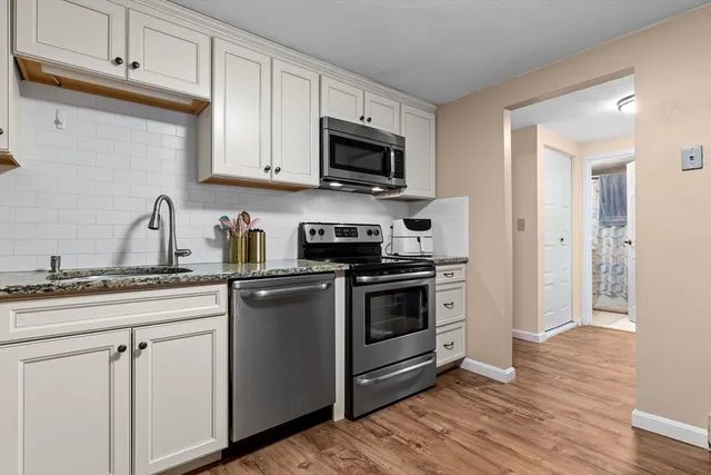 a kitchen with stainless steel appliances granite countertop a stove a sink and a microwave